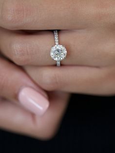 a woman's hand with a diamond ring on it