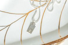 This dainty dog tag necklace can be personalized to make a special gift for her. Choose upper or lower case letter and choose the font. This necklace features - a sterling silver mini dog tag charm - engraving with a letter and font of your choice - a mini ball chain with lobster clasp - lengths from 16-20 inches Your new necklace will arrive in a gift box. To see our full line of jewelry, please visit http://www.austindowntoearth.etsy.com Silver Charm Necklace With Rectangular Pendant And Initials, Minimalist Silver Dog Tag Charm Necklace, Minimalist Dog Tag Charm Necklace As Gift, Minimalist Dog Tag Charm Necklace For Gift, Silver Letter Necklace, Letter Necklace Silver, Tiny Dog, Special Gifts For Her, Mini Dogs