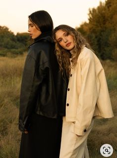 two women standing next to each other in a field