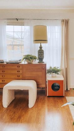 a living room filled with furniture and a lamp on top of a hard wood floor