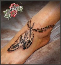 a woman's foot with a tattoo on it and a feather in the middle