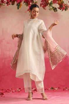 White organza kurta with silver mukaish embroidery and gathered on waistband. Paired with pant and floral hand block print dupatta.
Components: 3
Pattern: Embroidery, Hand Block Print
Type Of Work: Mukaish, floral
Neckline: Round high neck
Sleeve Type: Half sleeves
Fabric: Kurta and Dupatta: Organza, Pant: Chanderi Silk
Color: White
Other Details: 
Sheer panelled pant hem
Note: Inner worn by the model is not for sale
Occasion: Work,Puja - Aza Fashions Celebration Organza Palazzo Set With Sheer Dupatta, Transitional Chanderi Palazzo Set With Sheer Dupatta, Designer White Organza Palazzo Set, White Organza Palazzo Set For Designer Wear, White Silk Sets With Sheer Dupatta, White Silk Set With Sheer Dupatta, Festive White Kurta With Sheer Dupatta, Elegant Mulmul Dupatta With Gota Work, Festive Organza Kurta For Transitional Season