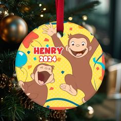 a christmas ornament hanging from a tree with a monkey on it's face