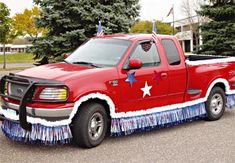 a red pick up truck decorated with stars and fringes