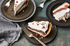 two black plates with slices of pie on them and one slice has been cut off