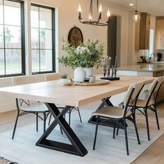 a dining room table and chairs in front of a window with an area rug on the floor