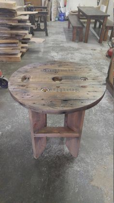 a wooden table sitting inside of a room filled with lots of tables and stools