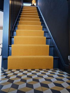 the stairs are painted yellow and black with checkerboard flooring on both sides