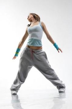 a woman in grey pants and white top dancing