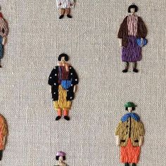 several embroidered images of people standing together on a white cloth with multicolored threads