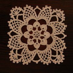 a crocheted doily on a wooden surface