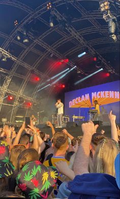 a group of people standing on top of a stage with their hands in the air