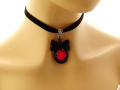 "Gothic choker Goth necklace Gothic jewelry Goth jewelry Gift for her Red Rose Black Cameo Necklace on Black Velvet choker Matching ring Gothic red rose cameo on a black background, set in a black acrylic bow tie topped frame. The cameo hangs from a velvet choker with a silver toned extender chain adjustable from 12.5 to 14.25 inches Cameo pendant - 2 inches Velvet choker necklace: 12.5-14.24 inches Arrives with a Marty White card in a lovely decorative bag and bubble wrap packaging. Facebook: h Emo Style Necklaces As Gifts, Gothic Adjustable Round Necklace, Gothic Round Adjustable Necklace, Red Emo Necklace For Gift, Emo Necklace For Valentine's Day Gift, Emo Style Necklace For Valentine's Day Gift, Adjustable Red Gothic Jewelry, Handmade Emo Style Necklace As Gift, Handmade Emo Style Necklace For Gift