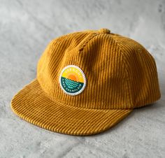 This is a KIDS size hat!  Adjustable back strap but probably fits toddler to 8year olds best. If your kid has an adult size head this hat may be too small.  Fun mustard yellow corduroy with our original Lake Champlain Vermont patch sewn on in our Vermont studios Flat brim, metal adjustable tab in back Unstructured 100% cotton Casual Gold Flat Bill Hat, Yellow Baseball Cap With Flat Bill, Yellow Flat Brim Baseball Cap, Casual Adjustable Gold Baseball Cap, Casual Gold Flat Brim Baseball Cap, Yellow Adjustable Snapback Hat With Flat Brim, Yellow Adjustable Flat Brim Snapback Hat, Adjustable Yellow Hat With Flat Bill, Casual Yellow 5-panel Snapback Hat