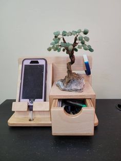 a cell phone is sitting on top of a desk with a tree in the middle