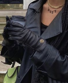 a woman wearing black leather gloves and a necklace