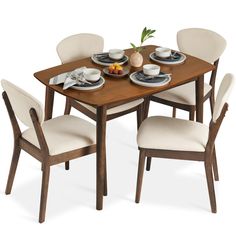 a wooden table with four chairs around it and plates on the plate holders at the top