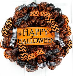 a happy halloween wreath with black and orange decorations on it's front door hanger