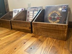 three wooden boxes with cds in them sitting on a table