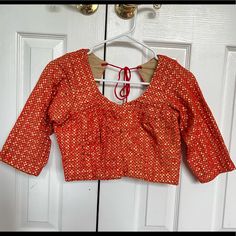 Red Blouse, Very Pretty Fabric Details, Never Worn Looks Like New. Not Padded With Bra ( Can We Worn Inside) Bust - 35” ( Note That There Is .5” Margin To Open Up The Blouse) Waist - 30” ( There Is Total Of 1” Margin To Open, .5” On Both Side) Blouse Length - 14” Sleeve Length - 13.5” Sleeve Circumference - 10” Blouse Front Open - 7” Back Open - 10” Feel Free To Combine With My Other Listings Of Sarees And Send Me An Offter! Thank You For Visiting My Closet! Orange V-neck Blouse For Party, Red Long Sleeve Top For Festivals, Festive Orange Unstitched Blouse, Fitted Orange Blouse For Party, Fitted Traditional Orange Top, Fitted Long Sleeve Red Choli, Red Fitted Long Sleeve Choli, Fitted Red Long Sleeve Choli, Festive Red V-neck Blouse