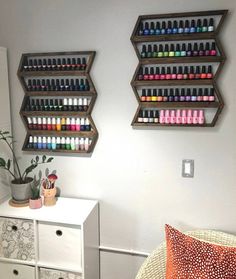 two wall mounted shelves with nail polish bottles on them and a plant in the corner