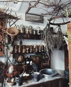 an old fashioned kitchen with lots of pots and pans on the shelves above it