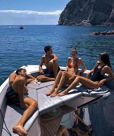 several people are lounging on the back of a boat