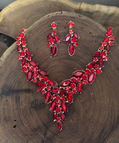 "These fun and stylish red large crystal rhinestone necklace and earrings are a great statement piece! Pageant, prom, or bridal!  Necklace Size: 16\" and 3\" extension Decor Dangle Length: 2\" Size of earrings: 1.75\" Long.  Color: red crystals Base metal color: gold Looking for a matching bracelet? https://www.etsy.com/listing/606549267/red-bracelet-red-rhinestone-bracelet-red?ref=shop_home_active_8 https://www.etsy.com/listing/538148439/red-crystal-bracelet-large-crystal?ref=shop_home_active_3 Red Gown Jewelry Ideas, Red And Pink Jewelry, Red Quince Necklace, Red Prom Accessories, Red Prom Jewelry, Red Jewellery Set, Red And Gold Jewelry, Red Jewelry Necklace, Choker Necklace Outfit