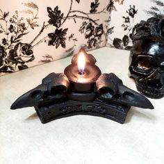 a candle that is sitting on top of a table next to a skull head statue