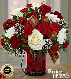 a bouquet of red and white flowers on a table next to a gold medal for better homes