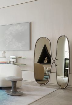 a living room with two mirrors on the wall and furniture in front of each other