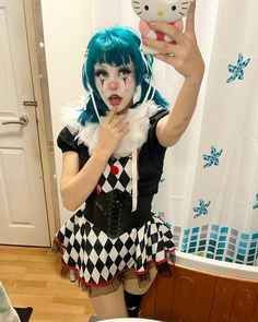 a woman with blue hair and makeup is taking a selfie