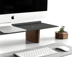 an apple computer sitting on top of a desk next to a keyboard and mouse pad