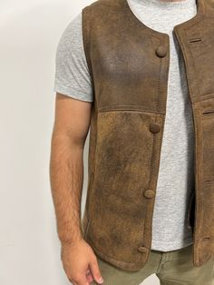 Perfect for three seasons, with the choice to layer on cooler days. Our sheepskin vest are durable, stylish and 100% natural allowing for your body to regulate warm in a productive way. Do you hate how body heat feels from polyester or synthetic fabrics? Then natural sheepskin and wool is the right choice for you. Our rancher vest is made from 100% leather and lined with 100% black mutton sheepskin. Our first model is wearing a size Large, is 6’ 5” and 175 pounds Our second model is wearing a si Rugged Leather Vest Outerwear, Rugged Brown Vest Outerwear, Rugged Fitted Vest Outerwear, Fitted Sleeveless Rugged Outerwear, Rugged Brown Winter Vest, Brown Rugged Vest For Winter, Leather Winter Outdoor Vest, Brown Rugged Winter Vest, Classic Brown Outdoor Vest