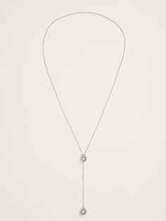 This stylish and versatile lariat is perfect worn alone or as a layering piece.  A clever spherical silicone slider bead slides along the delicate chain to adjust the length and spacing of spheres on the necklace.  Gold-plated or silver-plated brass.  Made in China.  Length: 28" Spheres diameters: 0. 5" Adjustable Dainty Round Lariat Necklace, Adjustable Round Lariat Necklace In Dainty Style, Elegant Lariat Necklace With Sliding Knot, Elegant Lariat Jewelry With Sliding Knot, Classic Lariat Jewelry With Adjustable Length, Minimalist White Gold Lariat Necklace With Delicate Chain, Adjustable Delicate Chain Lariat Necklace, Silver Adjustable Single Strand Lariat Necklace, Adjustable Silver Single Strand Lariat Necklace