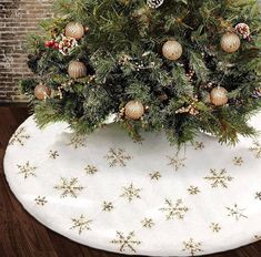 a small christmas tree on top of a white tablecloth with snowflakes and pine cones