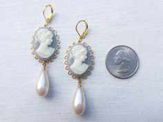 "These beautiful vintage inspired earrings were created with brass scalloped settings adorned with vintage Wedgwood blue Cameo cabochons and vintage cream teardrop pearls. These cameo statement earrings hang beautifully from lever-back ear wires and measure 2 3/4 inches in length and 3/4 inches in width. These earrings make the \"perfect gift\" for your mom, sister, daughter, friend, girlfriend, wife or bridesmaids....She will truly love these and treasure them for many years to come. All of my Bouquet Locket, Sentimental Wedding Gifts, Wedding Locket, Sentimental Wedding, Vintage Inspired Earrings, Victorian Earrings, Flamingo Earrings, Bouquet Charms, Cameo Earrings