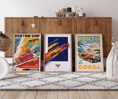 three framed posters are on the floor in front of a dresser and wall with other items