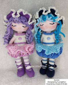 two crocheted dolls sitting next to each other