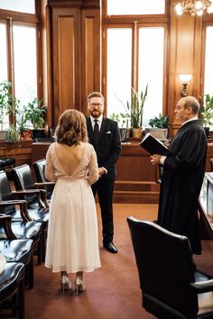 a man and woman standing in front of a priest