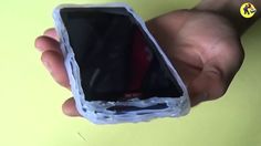 a hand holding an open cell phone in it's left side, with the screen partially covered by plastic