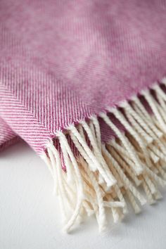 a pink and white blanket laying on top of a table