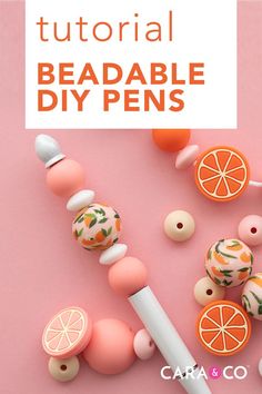 an orange and white beaded diy pen on a pink background with other beads