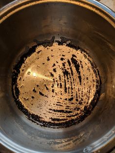 a metal bowl filled with dirt on top of a table