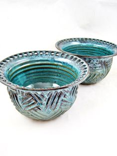 two blue glass bowls sitting next to each other