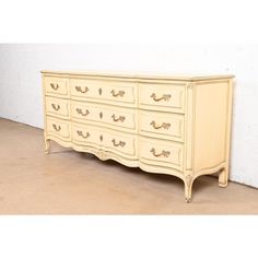 a white dresser with gold handles and drawers