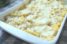 a casserole dish with pasta and cheese in it on a checkered table cloth