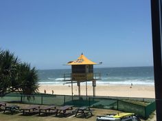 a lifeguard tower on the beach next to picnic tables