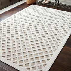 a large white rug on top of a wooden floor