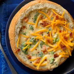 a blue plate topped with a pizza covered in cheese and broccoli